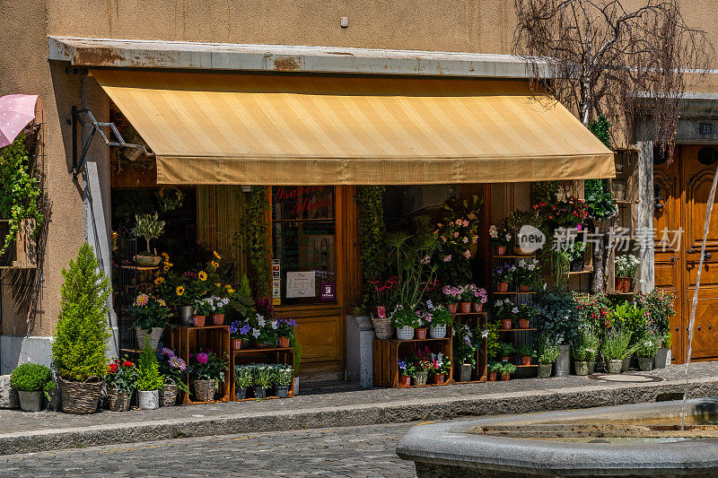 古老的花店有遮阳伞在晴天。19. 2019年7月-瑞士维伦纽夫。